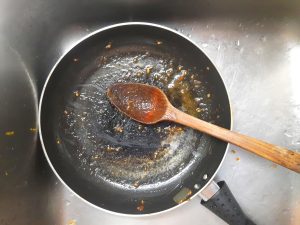 dirty pan on stovetop with wooden spoon
